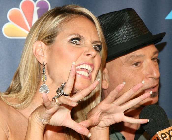 Heidi Klum playfully growls at the camera while wearing elegant, drop earrings during a red carpet event