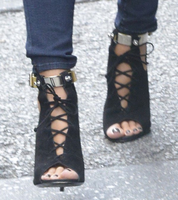 Heidi Klum's edgy Giuseppe Zanotti x Anja Rubik suede open-toe lace-up booties feature bold metallic ankle straps, intricate lace-up detailing, and a unique cutout design
