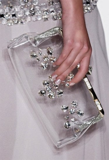 Jenny Packham's 'Mystery Palace' Clear Clutch, priced at £515, showcases modern elegance with its structured metal frame and embedded Swarovski crystals