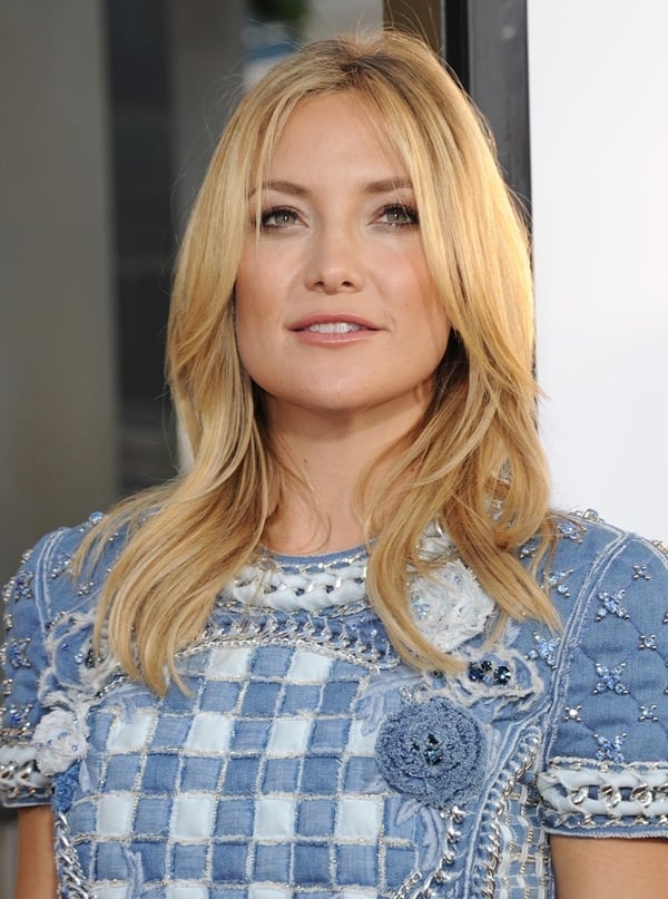 Kate Hudson wears a checkerboard patchwork dress with floral appliqués and chain accouterments