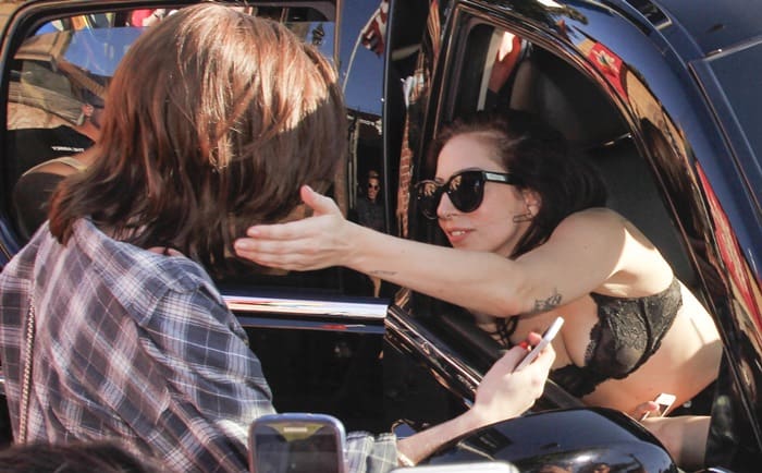 Lady Gaga showcases a bold black lace bra during a fan meet, pushing the envelope with her unique style