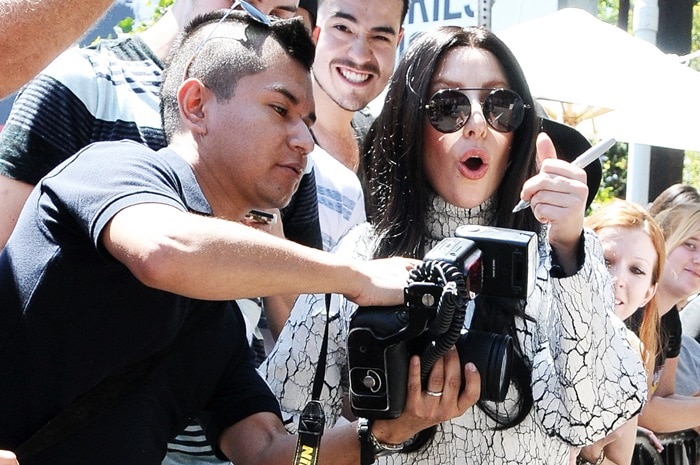 Engaging with fans, Lady Gaga signs autographs outside Chateau Marmont, Los Angeles, August 17, 2013