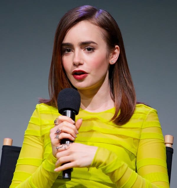 Lily Collins complements her yellow Versace with chic statement rings at the Soho Apple Store