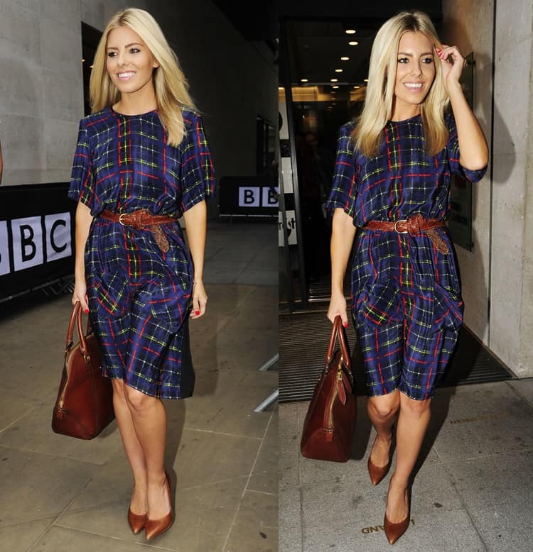 Mollie King elegantly combines fashion and functionality with her blue tartan dress, accessorized with a chic belt, classic pumps, and a tan Burberry Orchard bag during her BBC Radio 1 visit