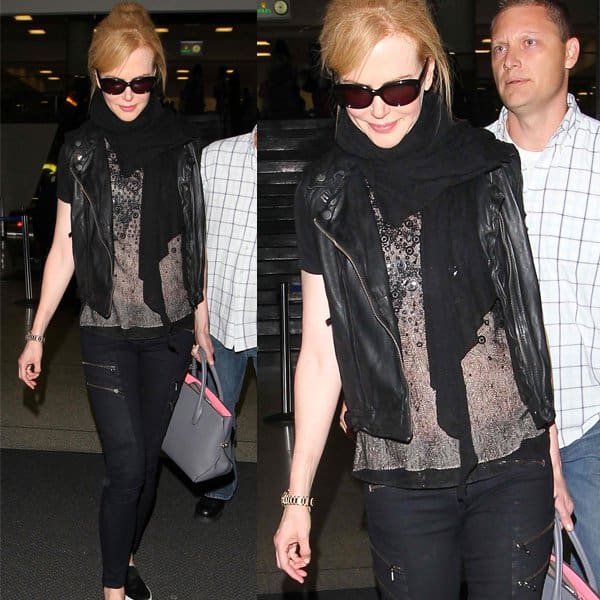 Nicole Kidman in an elegant all-black outfit featuring a Christian Dior purse and a pair of stylish Rag & Bone zippered black denim jeans