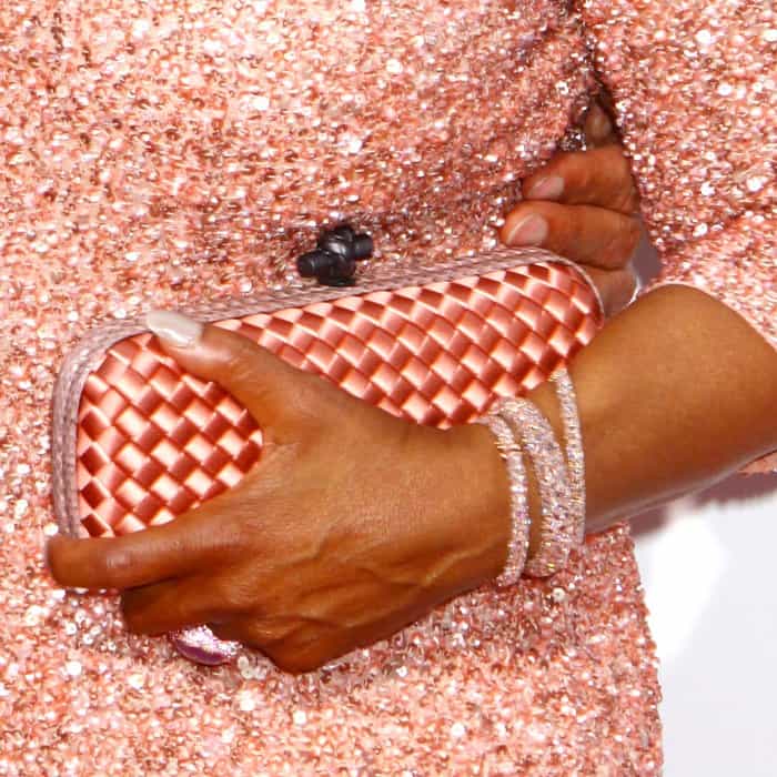 Oprah Winfrey carries a salmon-colored woven Bottega Veneta clutch