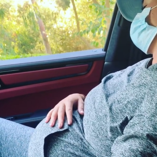 Katy Perry embraces laid-back maternity style in a heather gray matching set from Outdoor Voices, topped with a protective face mask and baseball cap