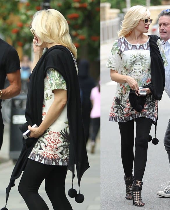 Gwen Stefani showcases her unique style in a floral dress paired with cage booties and a black pom-pom trim stole in London on August 19, 2013