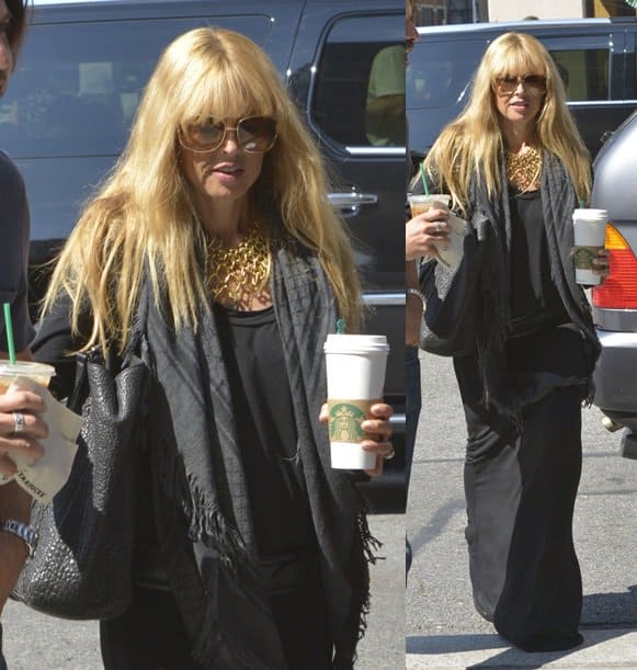 Rachel Zoe is effortlessly chic in an all-black ensemble, including a maxi dress and Gucci fringed shawl