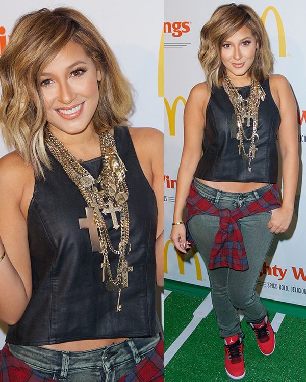 Adrienne Bailon with a plaid jacket tied around her waist at the launch of McDonald's New Mighty Wings