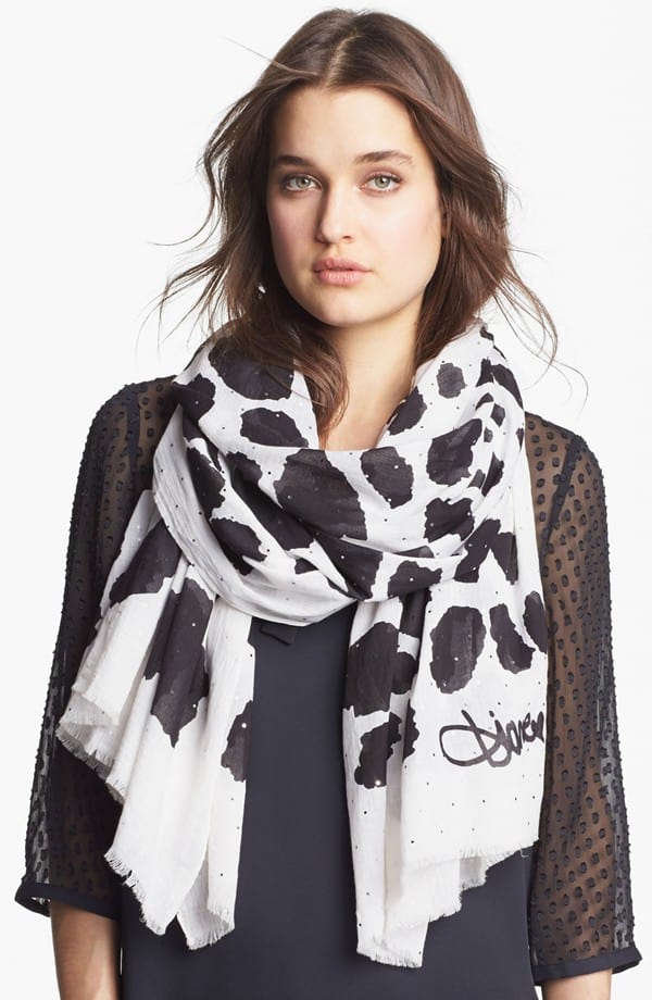 Bold spots splash across a classic fringed scarf embellished with tiny, silvery accents for a hint of sparkle and gleam