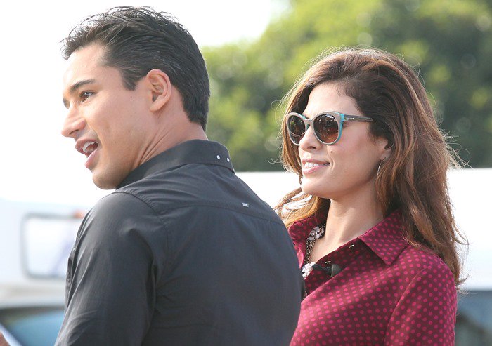 Eva Mendes and Mario Lopez engaged in lively conversation during a filming session of "Extra"