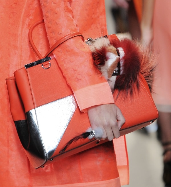 Fendi's vibrant orange handbag with metallic accents and fur embellishments, featured at Milan Fashion Week Spring/Summer 2014