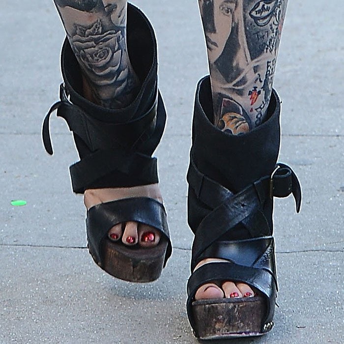 Kat Von D is wearing striking, unconventional black wedge sandals with thick, crisscrossing straps and a chunky wooden platform as she heads to Urth Caffé in Los Angeles, California, on September 19, 2013, showcasing her signature bold and edgy style
