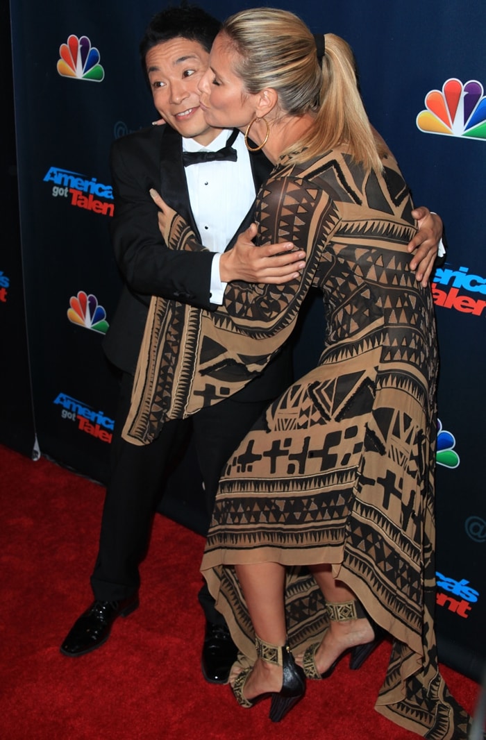 Kenichi Ebina, the winner of the eighth season of America's Got Talent, gets a kiss from Heidi Klum