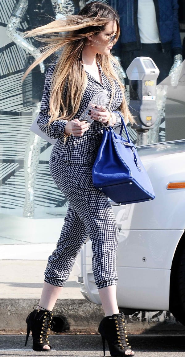 Khloe Kardashian showing off her hard-earned slimmer physique in a plaid jumpsuit by Theory