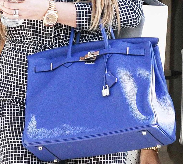 Elegance on the go: Khloé Kardashian accessorizes her monochrome outfit with a striking blue Hermès bag, adding a pop of color to her sophisticated look