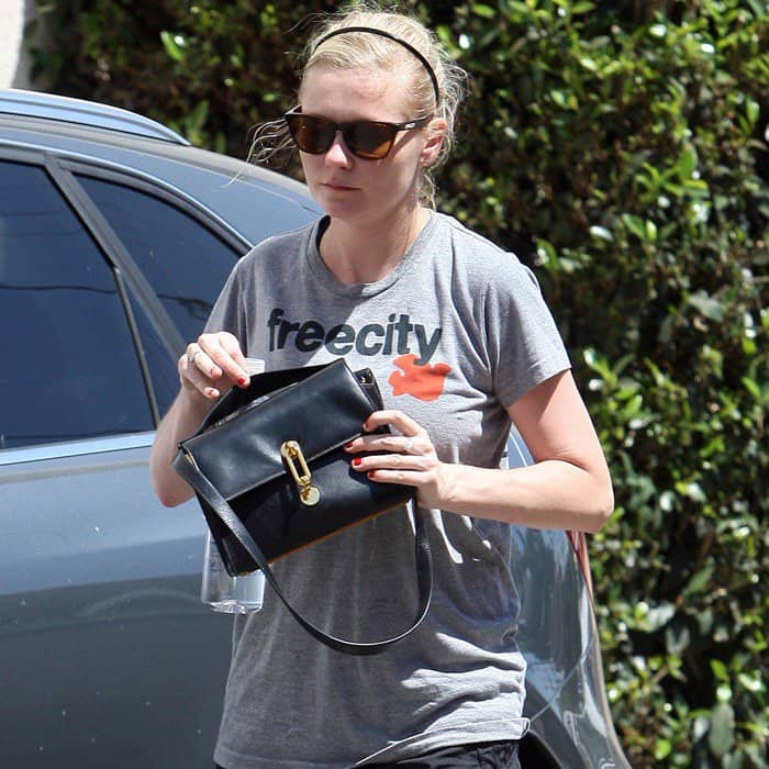 Kirsten Dunst looks sporty chic in a Freecity t-shirt paired with a stylish black boxy crossbody bag