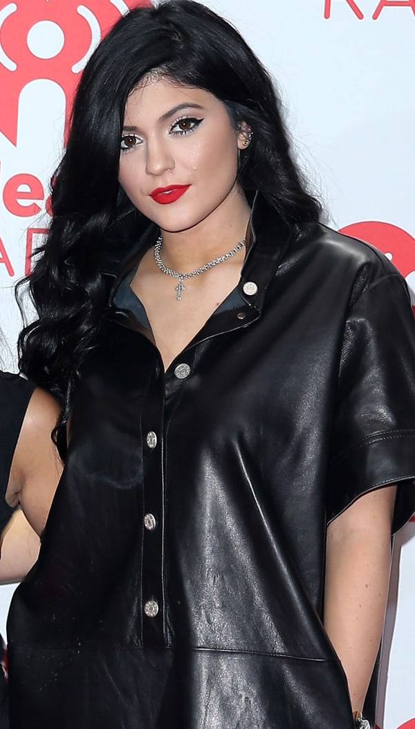 Kylie Jenner showcases her glam look with voluminous dark waves, bright red lips, and bold winged eyeliner at the iHeartRadio Music Festival