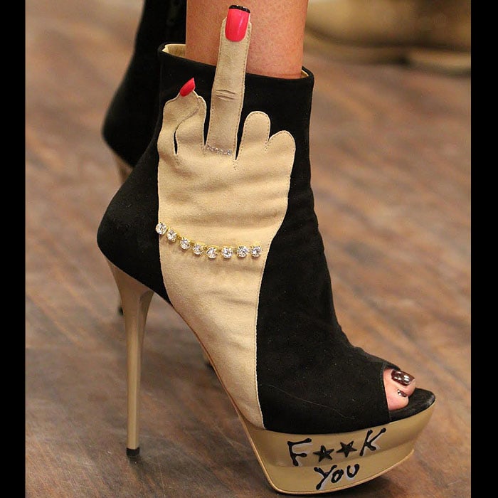 F**k You high heels with a manicured hand giving the finger