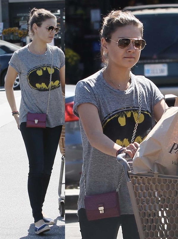 Mila Kunis is cool and casual in black leggings and a loose Batman t-shirt paired with canvas shoes