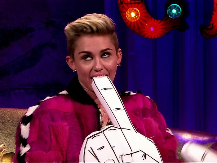 Miley Cyrus playfully biting on a foam finger during her interview on the Alan Carr: Chatty Man show