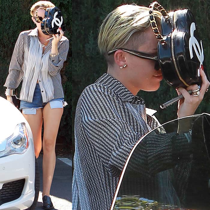 Miley Cyrus opts for privacy, shielding herself with a heart-shaped Chanel handbag upon arriving at a Los Angeles studio on September 4, 2013