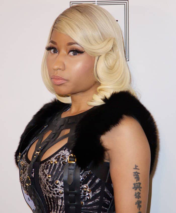 Nicki Minaj sports a glamorous vintage-inspired look with soft, side-swept blonde curls and flawless makeup
