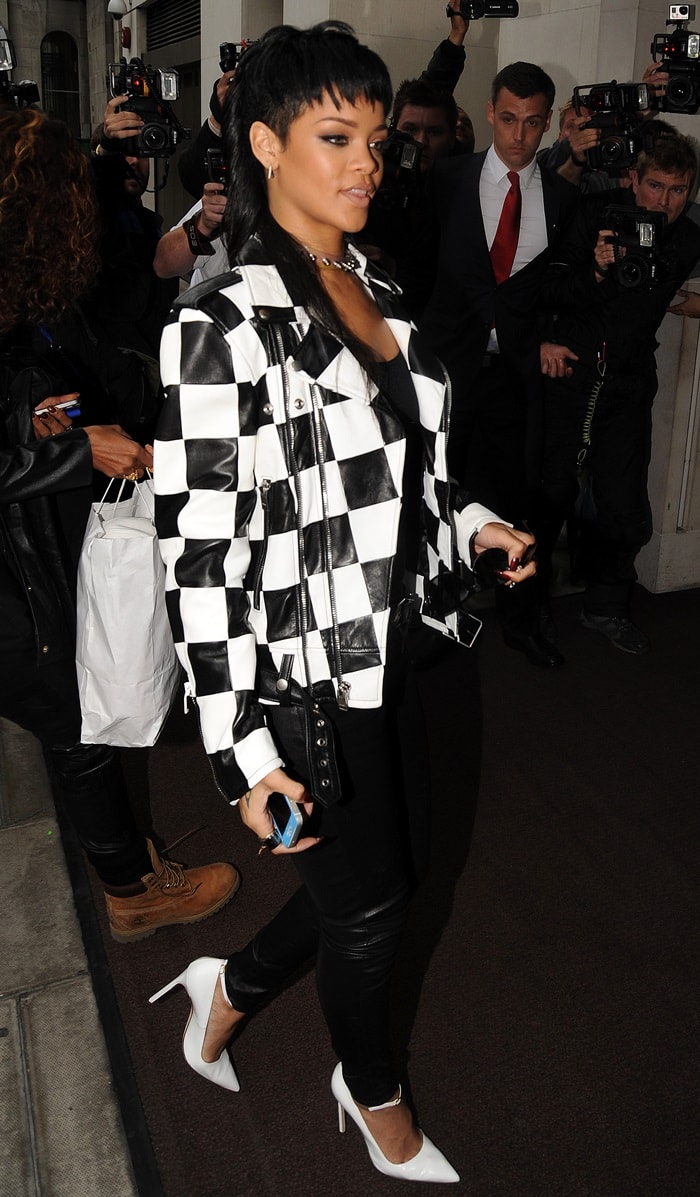 Rihanna wearing a monochromatic ensemble consisting of a Saint Laurent Spring 2014 black-and-white checkered jacket, J Brand skinny jeans, and white Manolo Blahnik pumps