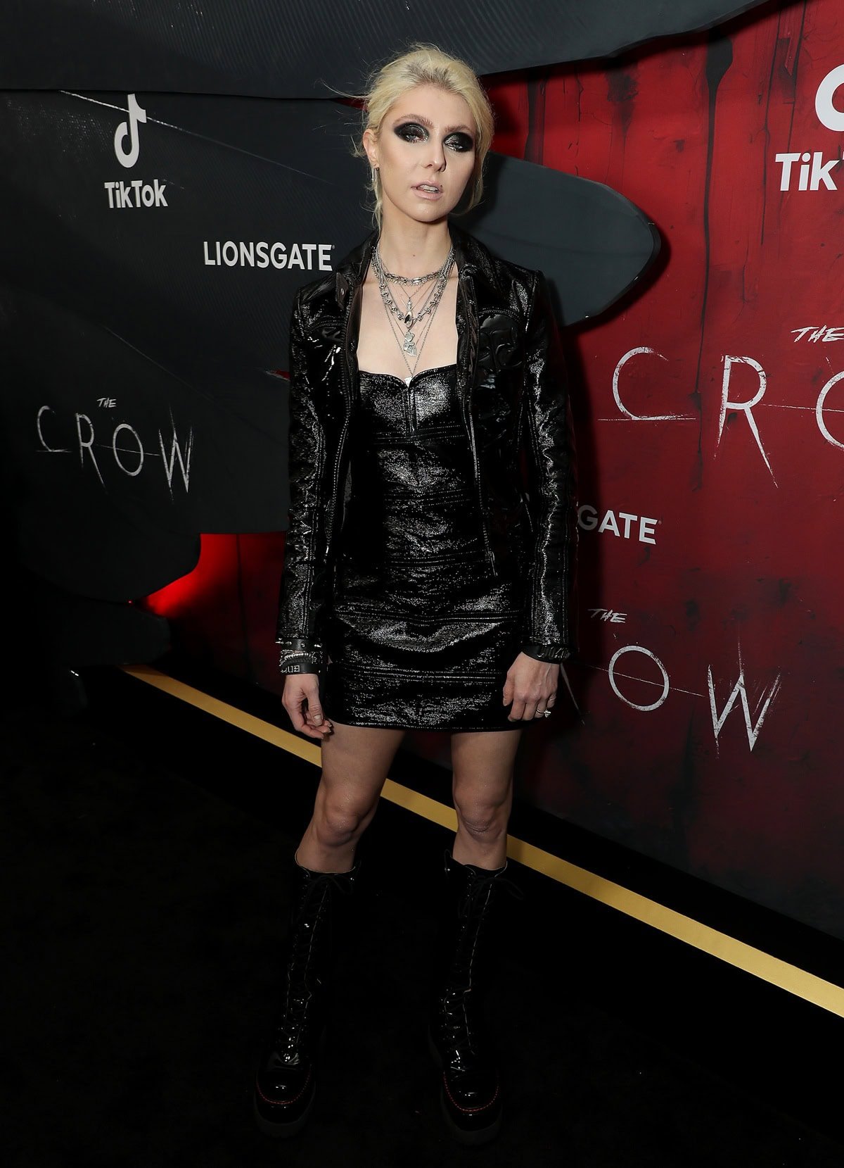 Taylor Momsen brought her gothic aesthetic to the black carpet in a paneled crushed patent leather Courrèges bustier minidress and matching jacket, styled with towering lace-up platform boots and layered silver necklaces