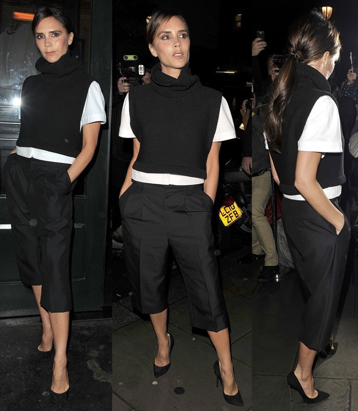 Victoria Beckham wearing black, calf-length culottes paired with a white shirt, a black roll-neck cropped jumper, and black heels