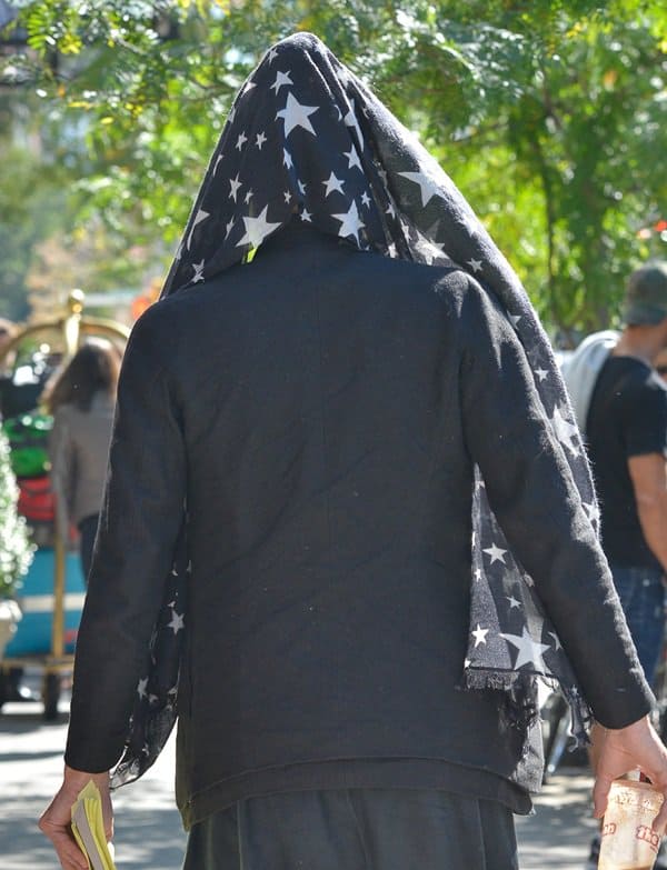 A back view of Russell Brand's star-printed scarf and layered jacket, showcasing his unique fashion sense