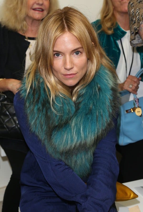 Sienna Miller attends the Matthew Williamson Spring 2014 presentation during London Fashion Week on September 15, 2013, showcasing her stylish fur accessory