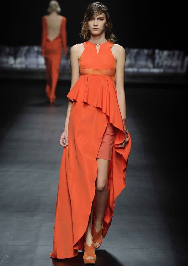Model showcasing an orange dress with beautiful draping by A Degree Fahrenheit