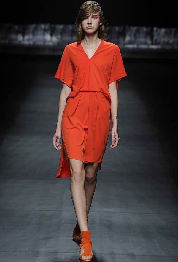 Model wearing an orange outfit featuring Yu Amatsu's signature patternmaking