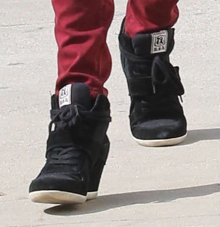 Alessandra Ambrosio steps out in stylish black wedge sneakers, effortlessly blending comfort and edge with her bold red jeans