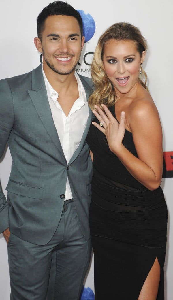 Alexa Vega showing her engagement ring alongside fiancé Carlos Peña at the premiere of 'Machete Kills'