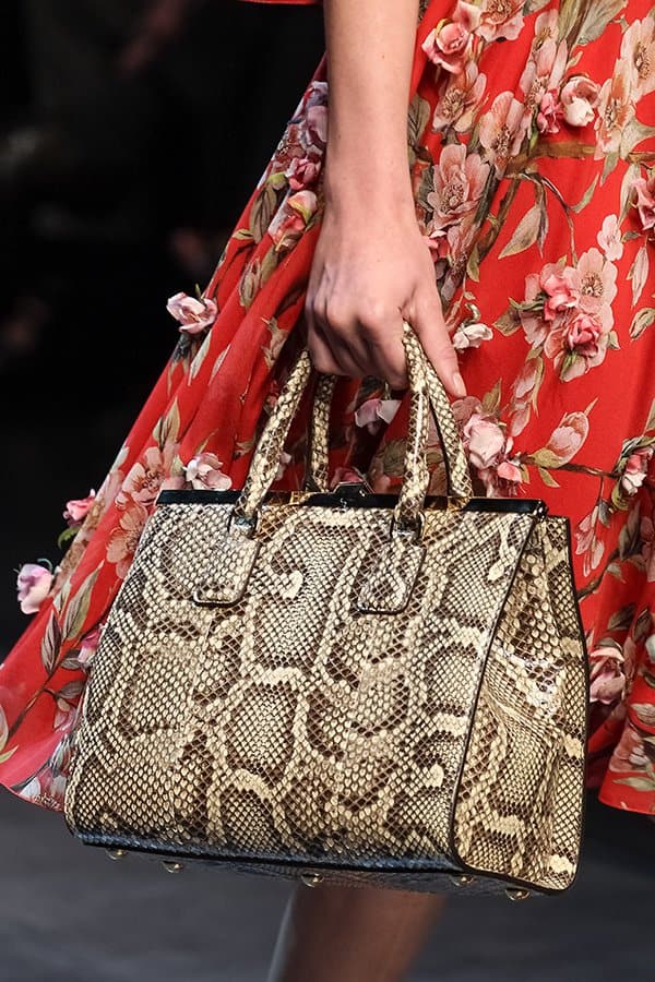The luxurious texture of the snakeskin bag perfectly complements the vibrant floral dress, creating a harmonious and stylish look