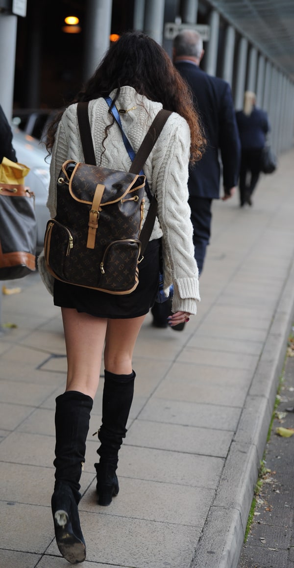 Eliza Doolittle at Manchester Piccadilly Train Station, Manchester, United Kingdom, on October 11, 2013, wearing a cozy knitted sweater, a miniskirt, and knee-high boots