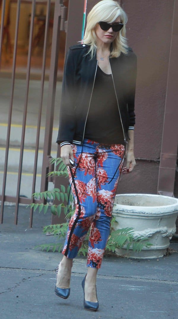 Gwen Stefani makes a bold statement in vibrant floral pants, a black bomber jacket, and classic heels