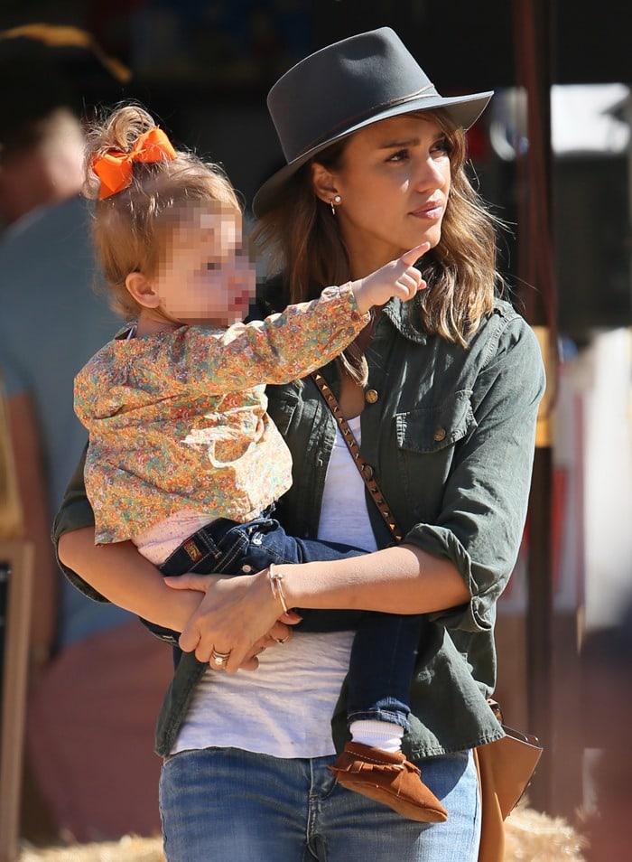 Jessica Alba looks effortlessly stylish in an army green jacket and fedora while spending time with her daughter at Mr. Bones Pumpkin Patch in West Hollywood