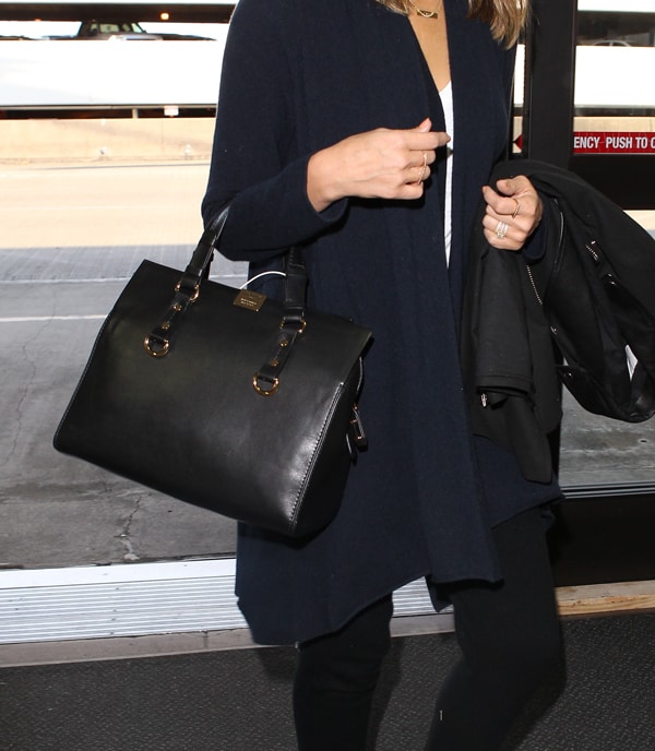 Jessica Alba arriving at LAX with a sleek black handbag and a leather jacket slung over her arm