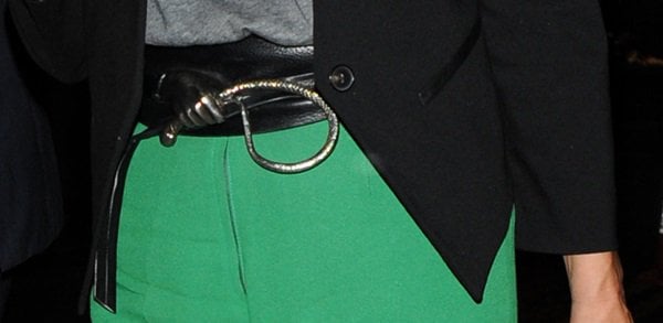 Kate Moss completes her chic look with a stylish belt, adding a touch of edginess to her bright green palazzo pants