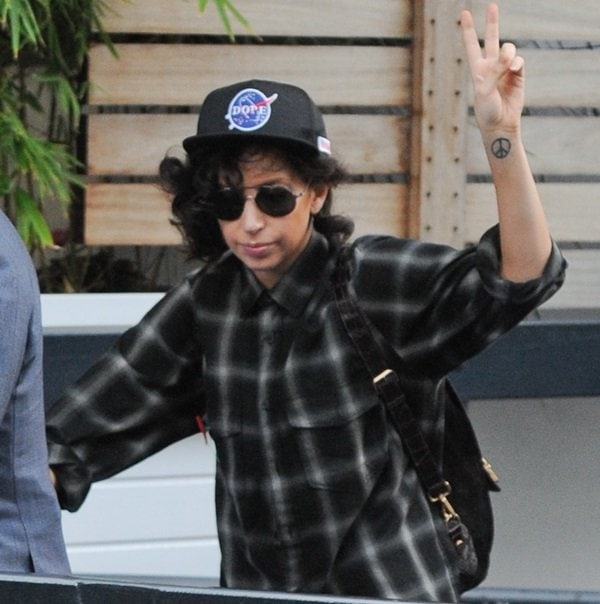 Lady Gaga flashes a peace sign and her peace sign tattoo as she arrives at ITV Studios in London