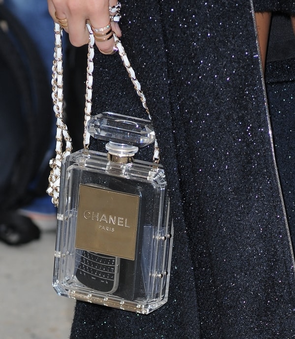 Miroslava Duma holding a Chanel No. 5 clutch, a standout accessory designed like the iconic perfume bottle