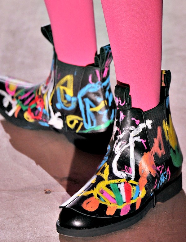 Black Chelsea boots with vibrant graffiti-style designs in bold colors, making a striking artistic statement