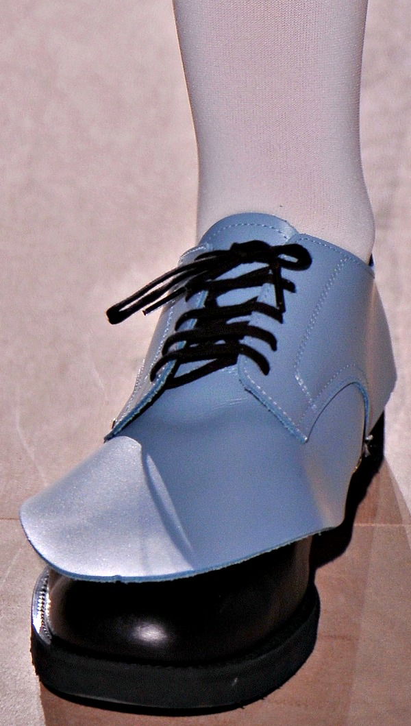 Powder blue oxford shoes featuring an exaggerated pointed overlay and bold black accents for a striking modern design