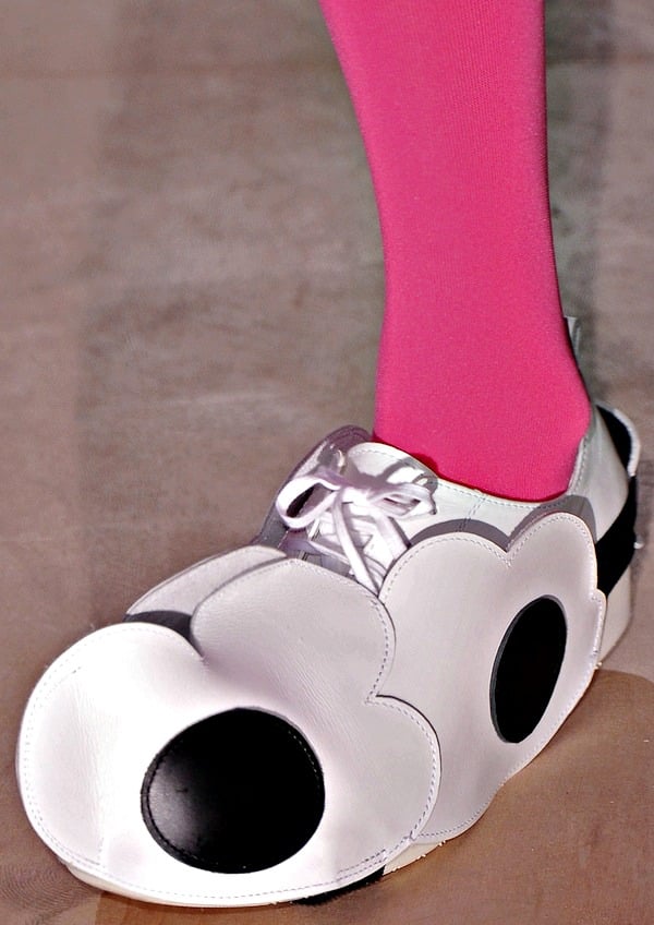 Whimsical white leather shoes with oversized floral cutouts and bold black accents