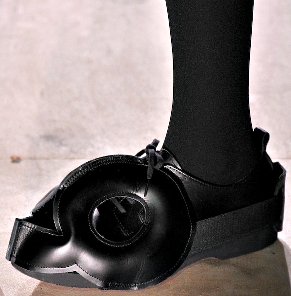 All-black shoes with a striking circular cutout and sculptural silhouette