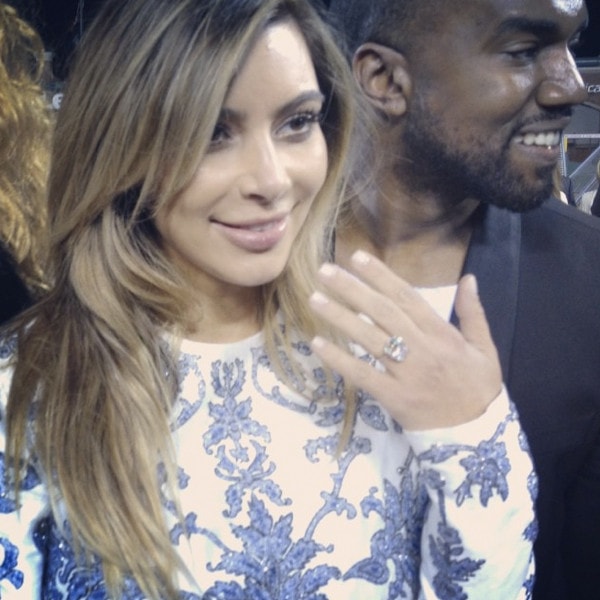 Kim Kardashian looking happy and glowing as she shows off her ring in a printed Valentino Fall 2013 dress